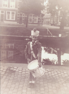862744 Portret van de 11-jarige Alex Jupijn, in het uniform van de drumband 'De Domstad', op de Nieuwekade in Wijk C te ...